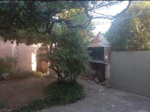 a brick building with a tree in a yard at Chalet Centrico in Merlo
