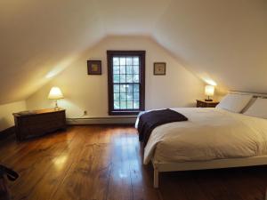 ein Schlafzimmer mit einem großen Bett und einem Fenster in der Unterkunft The Featherbed Inn in Waitsfield