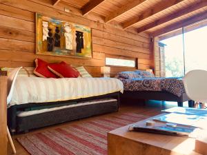 a bedroom with two beds in a log cabin at Wentreng-ko loft in Curacautín