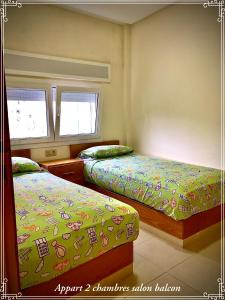 een slaapkamer met 2 bedden en 2 ramen bij Hôtel Réstinga Martil in Martil