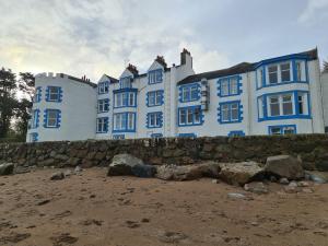 duży niebiesko-biały budynek na plaży w obiekcie Balcary Bay Country House Hotel w mieście Auchencairn