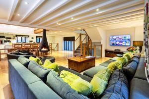 a living room with a blue couch and a tv at Finest Retreats - Bretherdale Barn in Tebay