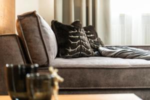 - un canapé avec des oreillers dans l'établissement Apartments Rainer - Val Gardena, à Ortisei