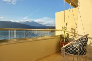 balcón con columpio y vistas al agua en Boho Beach House in Itea-Delphi, en Itea