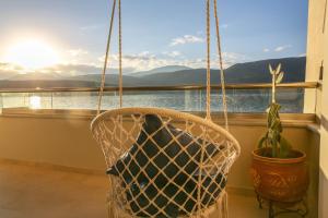 a hanging basket with a potted plant and a window at Boho Beach House in Itea-Delphi in Itea