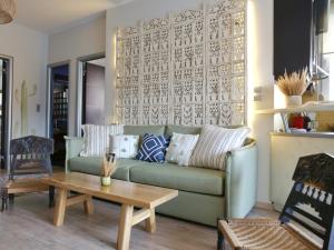 uma sala de estar com um sofá verde e uma mesa em Boho Beach House in Itea-Delphi em Itea