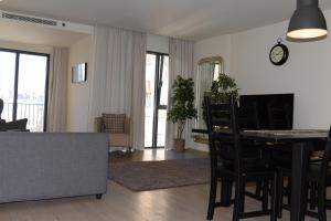 Lux Apartment with Pool and Garage في لشبونة: غرفة معيشة مع طاولة طعام وأريكة