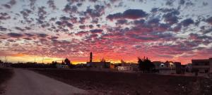 private room with cultural experience and great landscapes في Şirfah: سماء غائمة عند غروب الشمس مع طريق ترابي