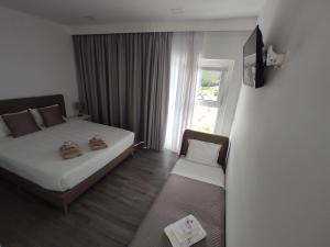 um quarto de hotel com uma cama e uma janela em Olhar Sobre o Alva - Turismo Rural e Sabores em São Sebastião da Feira