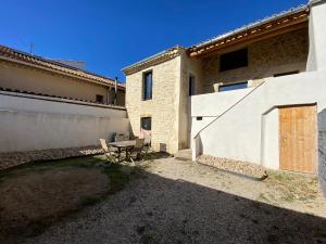 a patio with a table in front of a house at Charmante maison face à l’église de CODOLET in Codolet