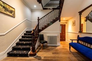 a staircase in a home with a blue couch at Royal Hotel Sheerness in Sheerness