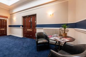 - une salle d'attente avec une table et des chaises dans l'établissement Royal Hotel Sheerness, à Sheerness