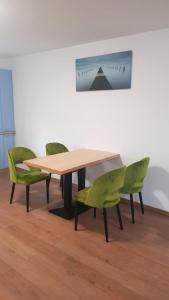 einen Tisch und zwei grüne Stühle in einem Zimmer in der Unterkunft Apartament 1 Budiu in Târgu Mureș