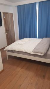 Bett in einem Zimmer mit einem blauen Vorhang in der Unterkunft Apartament 1 Budiu in Târgu Mureș