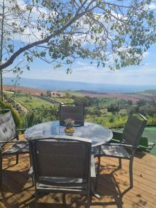 a table and chairs on a deck with a view at la noach in Metulla