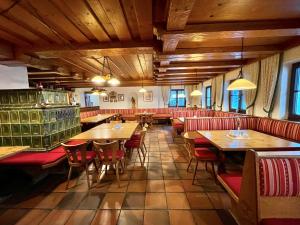 un restaurante con techos de madera, mesas y sillas rojas en Landgasthof Schwarzberg en Inzell