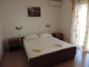 a bedroom with a bed with two towels on it at Apartmani Antica in Cres