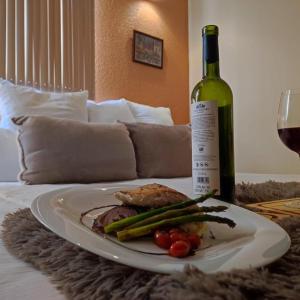 un plato de comida y una botella de vino en la cama en Hotel Express Quinta Soledad, en Ciudad de México