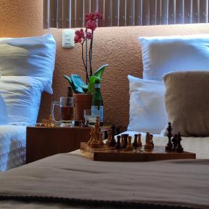 - un échiquier sur un lit avec un vase et des fleurs dans l'établissement Hotel Express Quinta Soledad, à Mexico