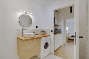 ein Badezimmer mit einer Waschmaschine und einem Spiegel in der Unterkunft Buttes Chaumont - Sunny 2P apartment in Paris