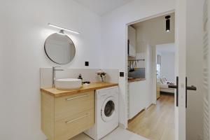 a bathroom with a washing machine and a mirror at Buttes Chaumont - Sunny 2P apartment in Paris