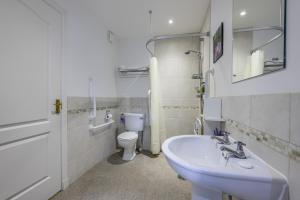 La salle de bains blanche est pourvue d'un lavabo et de toilettes. dans l'établissement Apartment 20 Inchmarlo, à Banchory