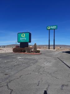 a gas station with two signs in the desert at Quality Inn & Suites Grants - I-40 in Grants