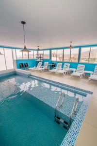 une grande piscine avec des chaises et une table dans l'établissement Hotel Costa Sol Moquegua, à Moquegua