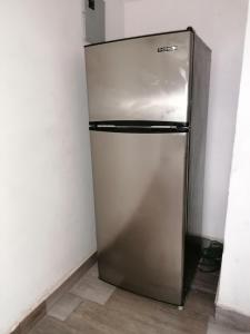a stainless steel refrigerator in a corner of a room at Black & White casa privada con alberca in Monterrey