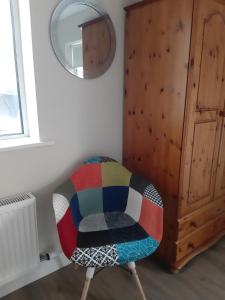 una sedia colorata in una stanza con specchio di Ben Haven Self Catering Accommodation a Ballaghnatrillick