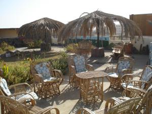 un grupo de sillas y mesas y una sombrilla en Western Desert Hotel & Safari, en Bawati