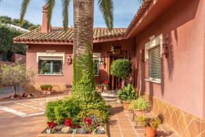 a house with a palm tree in the courtyard at Villa Olivar - 5 BDR Dream Pool/Jacuzzi/Golf/BBQ in Torremolinos
