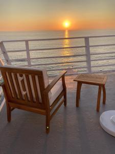a bench and a table on a balcony with a sunset at Laguna Surf Lodge in Laguna Beach