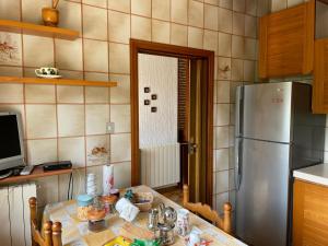 a kitchen with a table and a refrigerator at A casa di Zia Maria - Fuscaldoapartment in Fuscaldo +3 photos