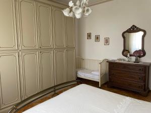 a bedroom with a bed and a dresser and a mirror at A casa di Zia Maria - Fuscaldoapartment in Fuscaldo
