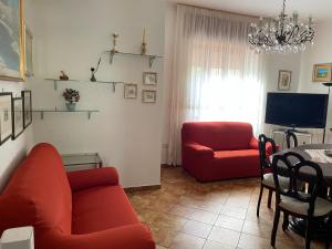 a living room with two red couches and a television at A casa di Zia Maria in Fuscaldo