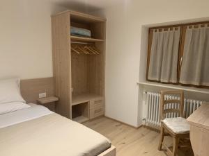 Schlafzimmer mit einem Bett, einem Schreibtisch und einem Fenster in der Unterkunft La locanda di Geppetto in Bedollo