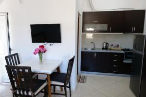 a kitchen with a table with a vase of flowers on it at Vila Ervin Second Floor in Ksamil