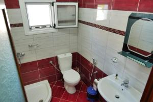 a bathroom with a white toilet and a sink at Vila Ervin Second Floor in Ksamil