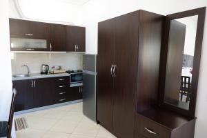 a kitchen with brown cabinets and a stainless steel refrigerator at Vila Ervin Second Floor in Ksamil