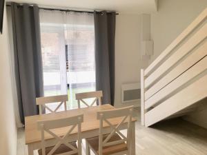 a dining room with a table and chairs next to a window at Domaine des 3 Villages in Bouchemaine