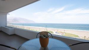 una mesa con vistas a la playa desde el balcón en Departamento frente al mar Iquique, en Iquique