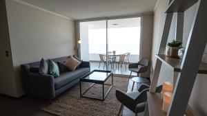 sala de estar con sofá y mesa en Departamento frente al mar Iquique, en Iquique