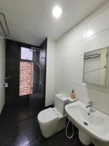 W łazience znajduje się umywalka, toaleta i lustro. w obiekcie HOMESTAY D'Univ 360 PLACE w mieście Seri Kembangan