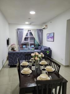 a dining room table with chairs and a blue couch at HOMESTAY D'Univ 360 PLACE in Seri Kembangan