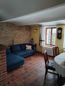 uma sala de estar com um sofá azul e uma mesa em Old Style Cottage em Horní Paseka