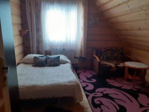niewielka sypialnia z łóżkiem i oknem w obiekcie Pod Modrzewiem w Bukowinie Tatrzańskiej