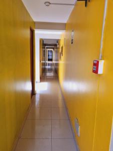 un pasillo vacío en un edificio de oficinas con paredes amarillas en Hostal refugio's, en Ica
