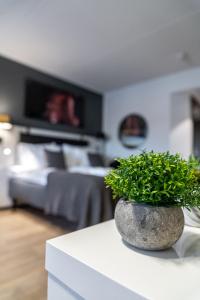 a vase with a plant on a counter in a bedroom at Hotelli Sointu in Järvenpää