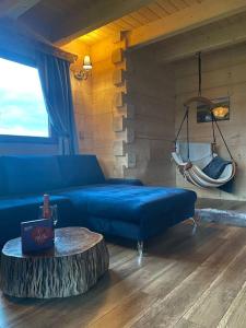 a living room with a blue couch and a log table at Little House in Ząb